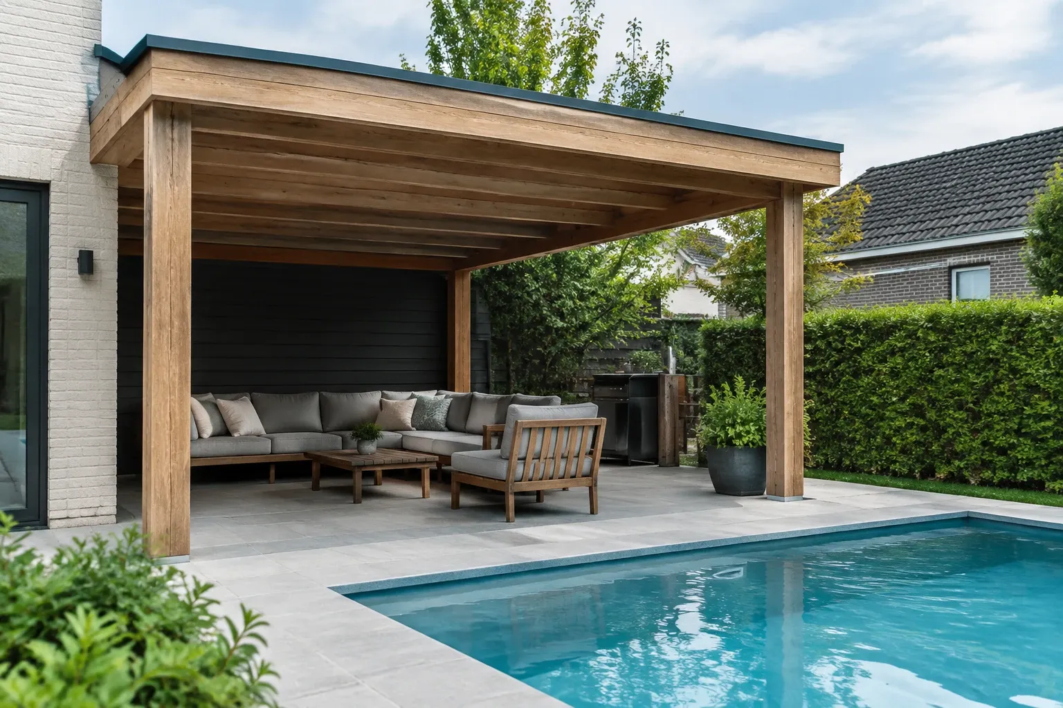 Houten tuinoverkapping met loungebank en tafel naast helder blauw zwembad